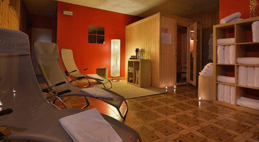 Entspannungsraum eines Spas mit Liegen, Handtüchern und Sauna.